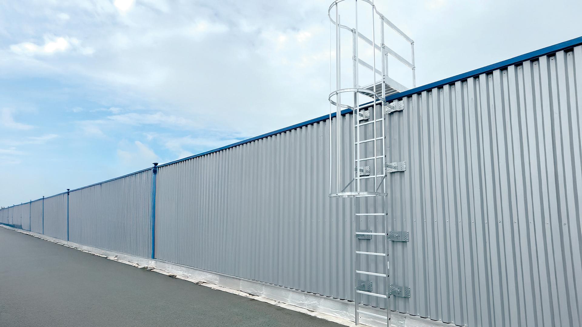  aluminum safety ladder with cage installed on an industrial metal wall