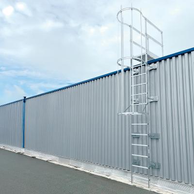 aluminum safety ladder with cage installed on an industrial metal wall