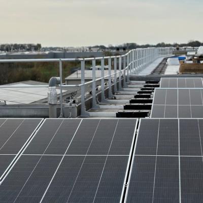 Rooftop solar panel installation with safety guardrails and secured access system