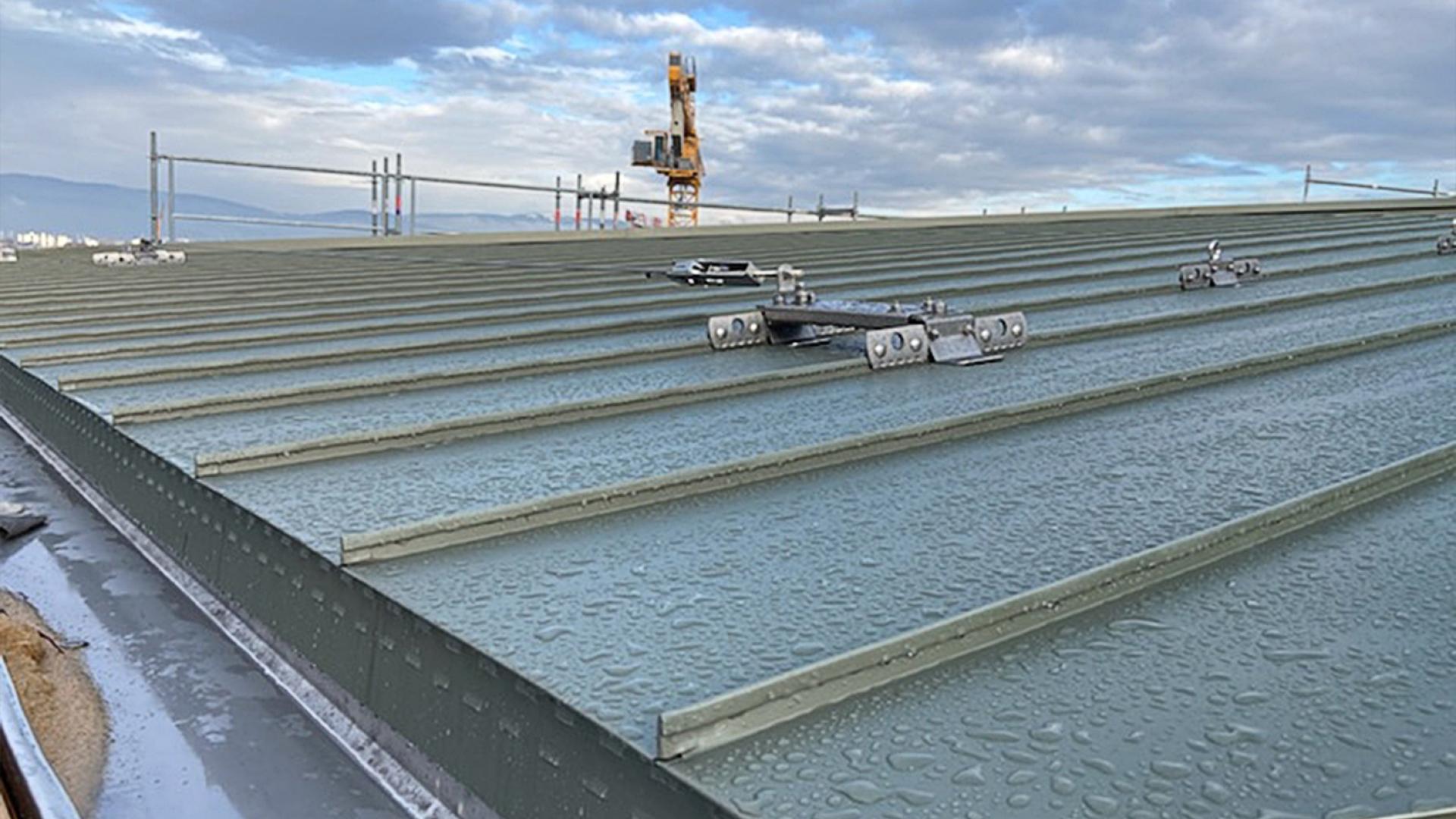 Standing seam metal roof with anchor point and visible moisture risk 