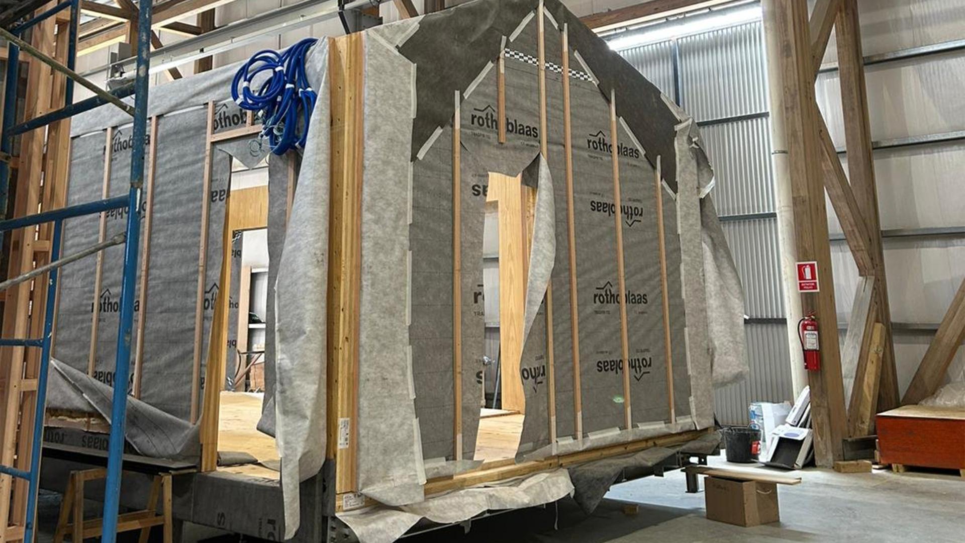 Applicazione di membrane traspiranti e nastri di tenuta su modulo prefabbricato in legno presso lo stabilimento MOOD