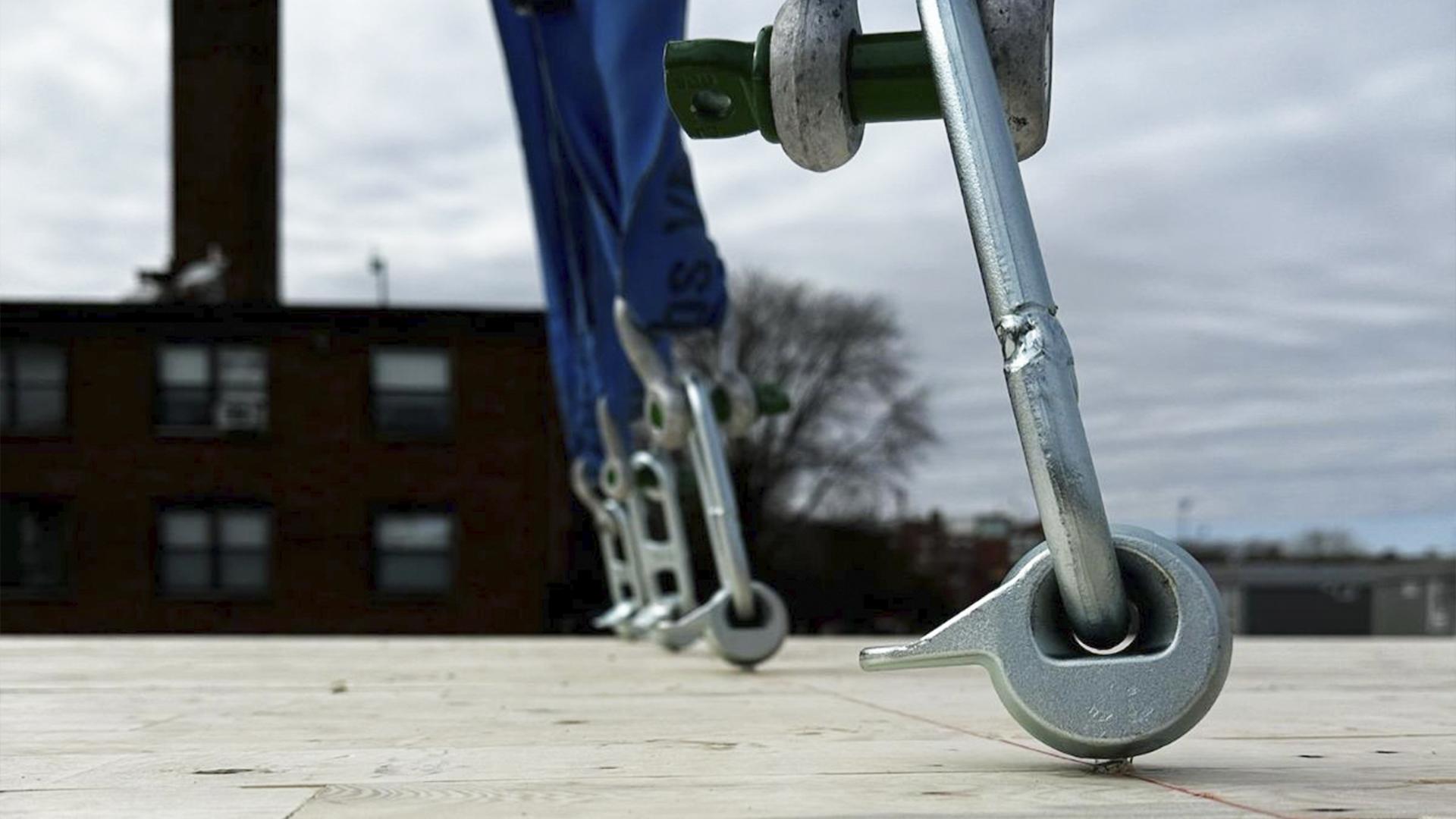 Reusable lifting strap with metal pin anchored to timber panel for on-site handling and lifting of prefabricated wooden elements 