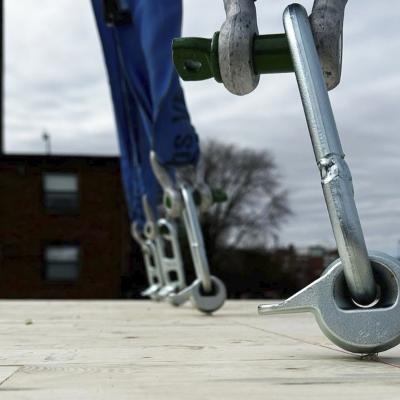 Reusable lifting strap with metal pin anchored to timber panel for on-site handling and lifting of prefabricated wooden elements