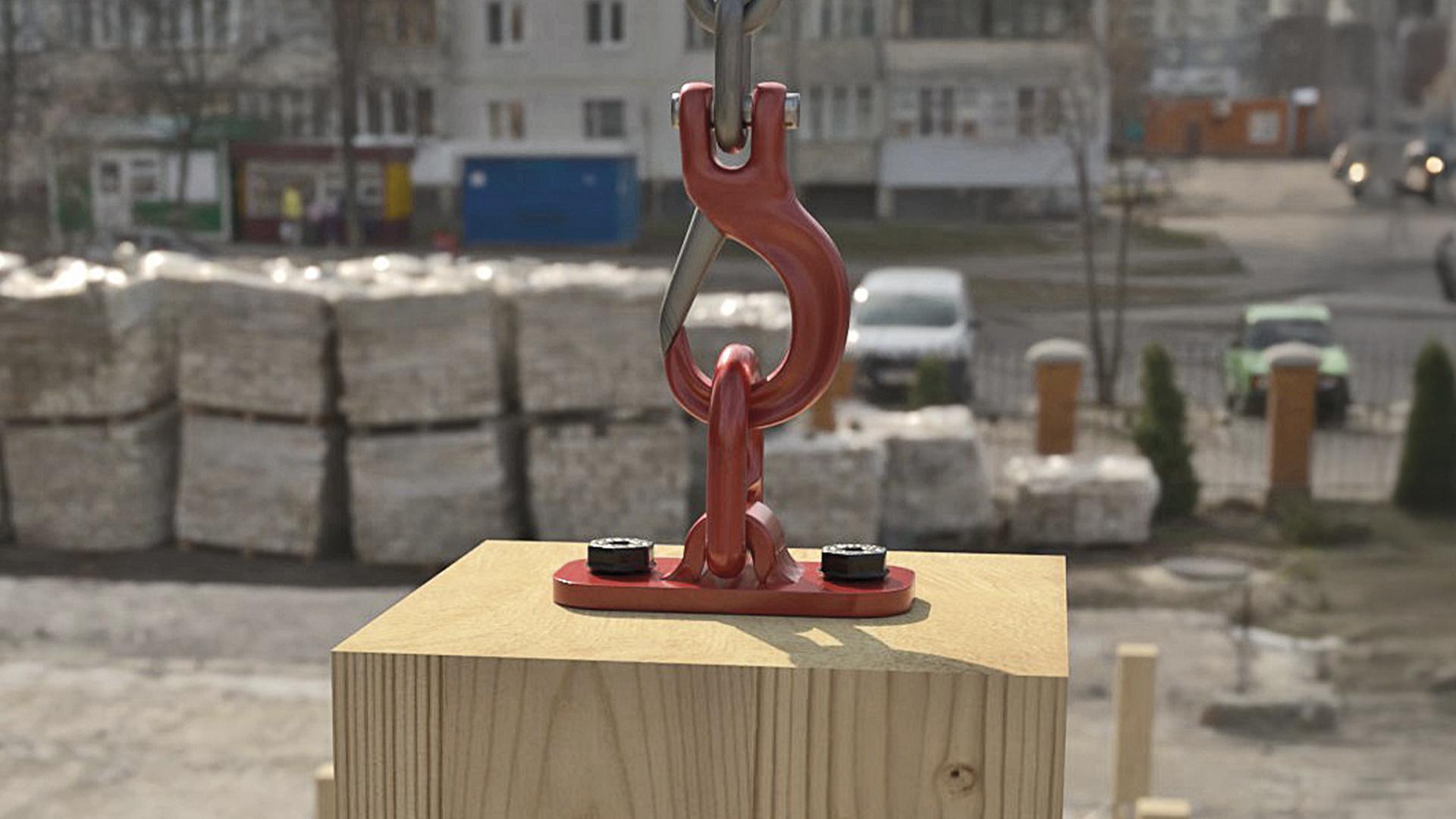 Metal lifting hook and plate fixed to timber element for crane lifting on construction site, designed for handling prefabricated wooden components