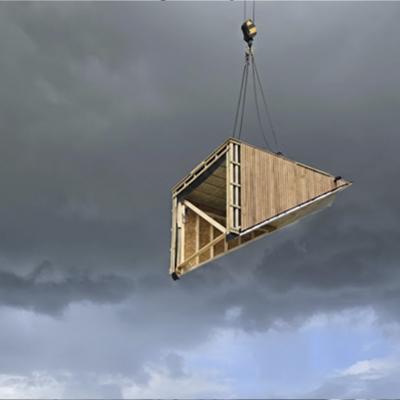 Crane lifting prefabricated timber room module on construction site using lifting equipment for wooden prefabricated buildings 