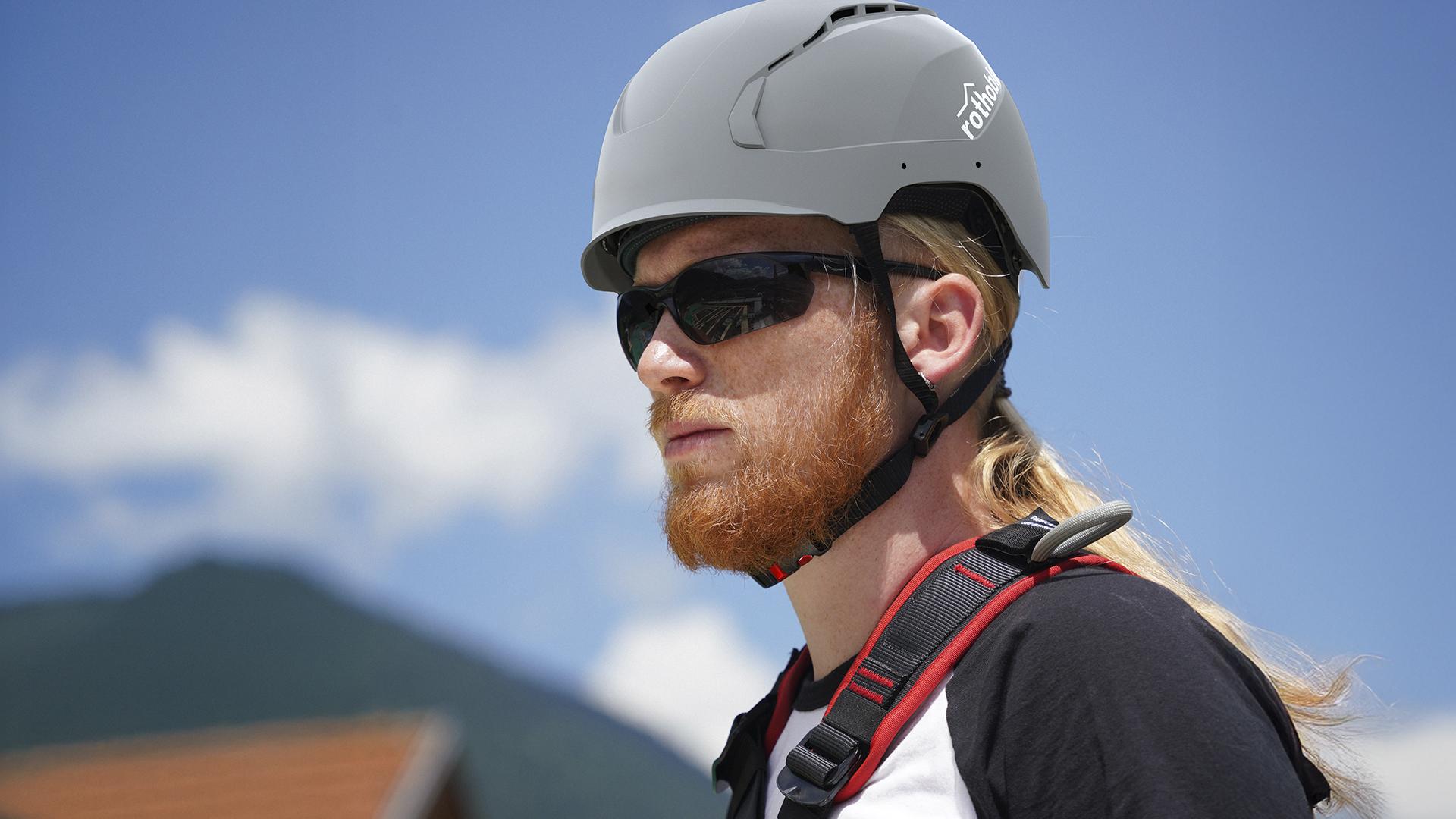 Worker wearing the Rothoblaas HERO safety helmet in iconic grey, certified EN 397:2025 Type II, in a work-at-height context 
