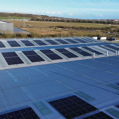 Industrial roof with photovoltaic panels and integrated skylight fall protection system for safe maintenance activities 
