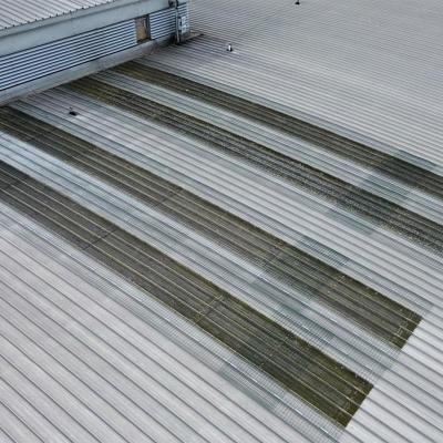 Permanent skylight fall protection system installed over fragile rooflights on corrugated metal industrial roof 