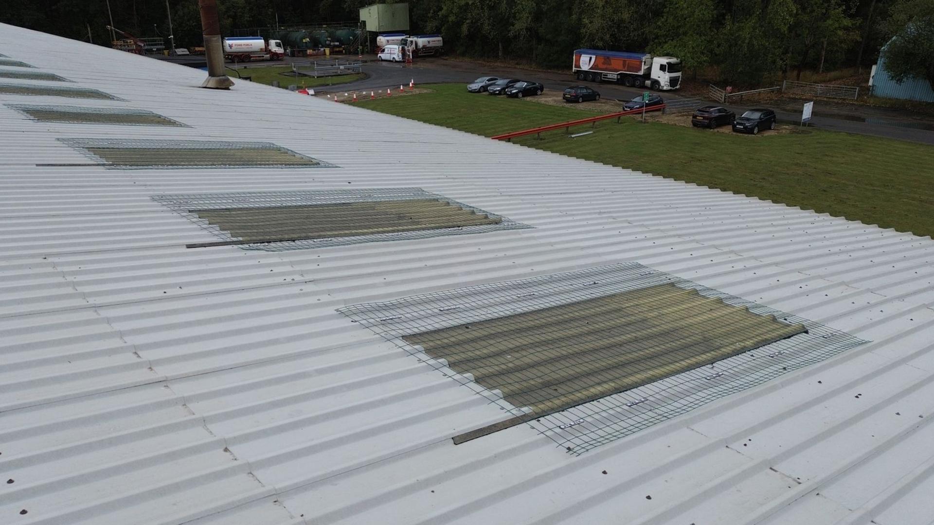 Skylight fall protection system installed on industrial metal roof to secure fragile rooflights during maintenance 