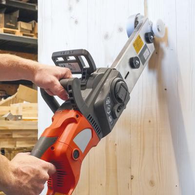 Professional woodworking machine performing a vertical cut on a solid timber panel using a carpentry chainsaw for structural wood processing.