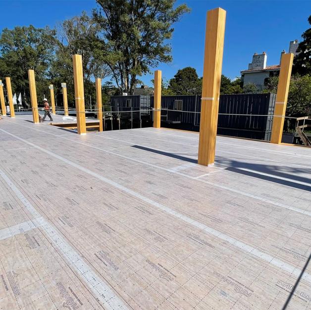 Mass timber construction site with self-adhesive breathable membrane applied on CLT floor for timber protection on site and moisture control. 