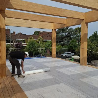 Installation of self-adhesive breathable membrane on CLT floor during mass timber construction for effective timber protection on site.