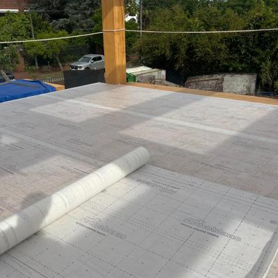 CLT floor with self-adhesive breathable membrane partially installed during mass timber construction for timber protection on site.