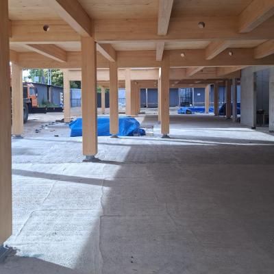 Mass timber structure with CLT beams and columns in construction, highlighting timber protection on site and structural system performance.