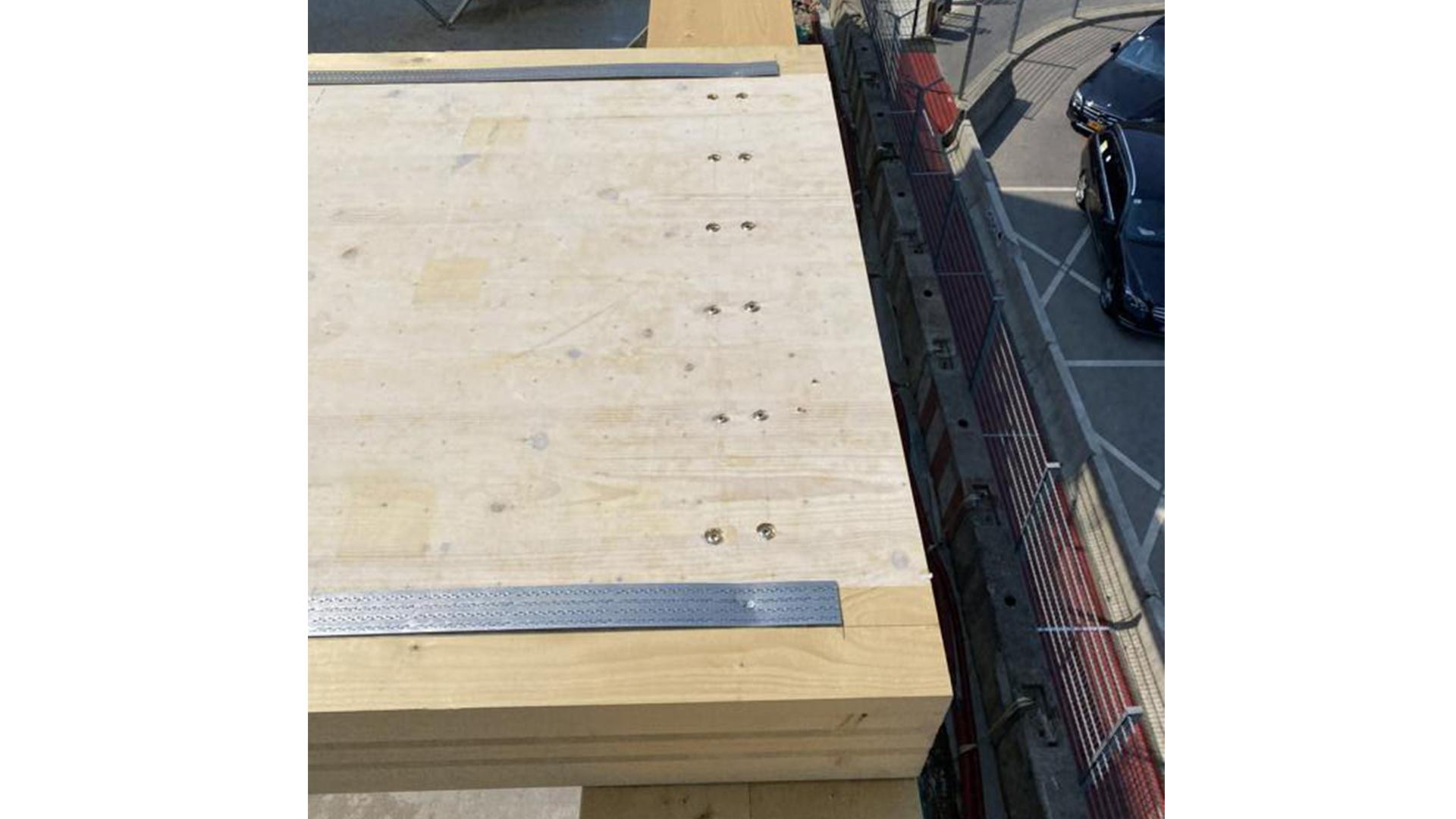Timber floor slab with protective membrane installed on mass timber structure during construction