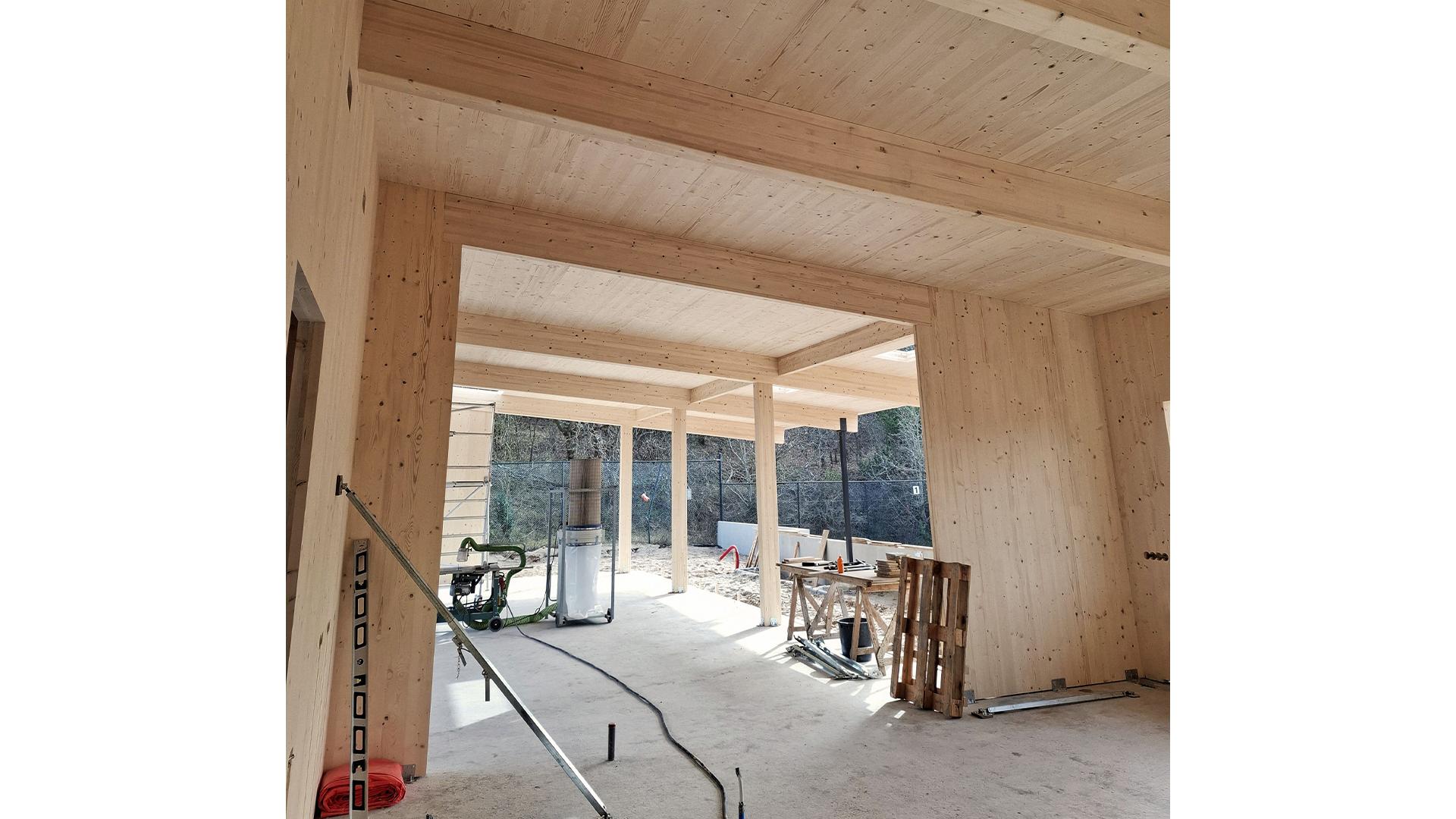 Interior of timber pavilion with exposed CLT panels and glulam beams 