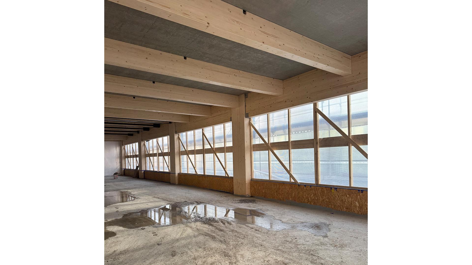 Engineered timber beams and columns in post and beam system with glulam structure and concrete slab in interior construction phase