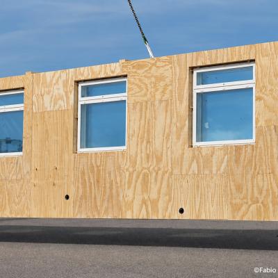 Prefabricated timber facade module with windows for off-site retrofit installation on existing buildings