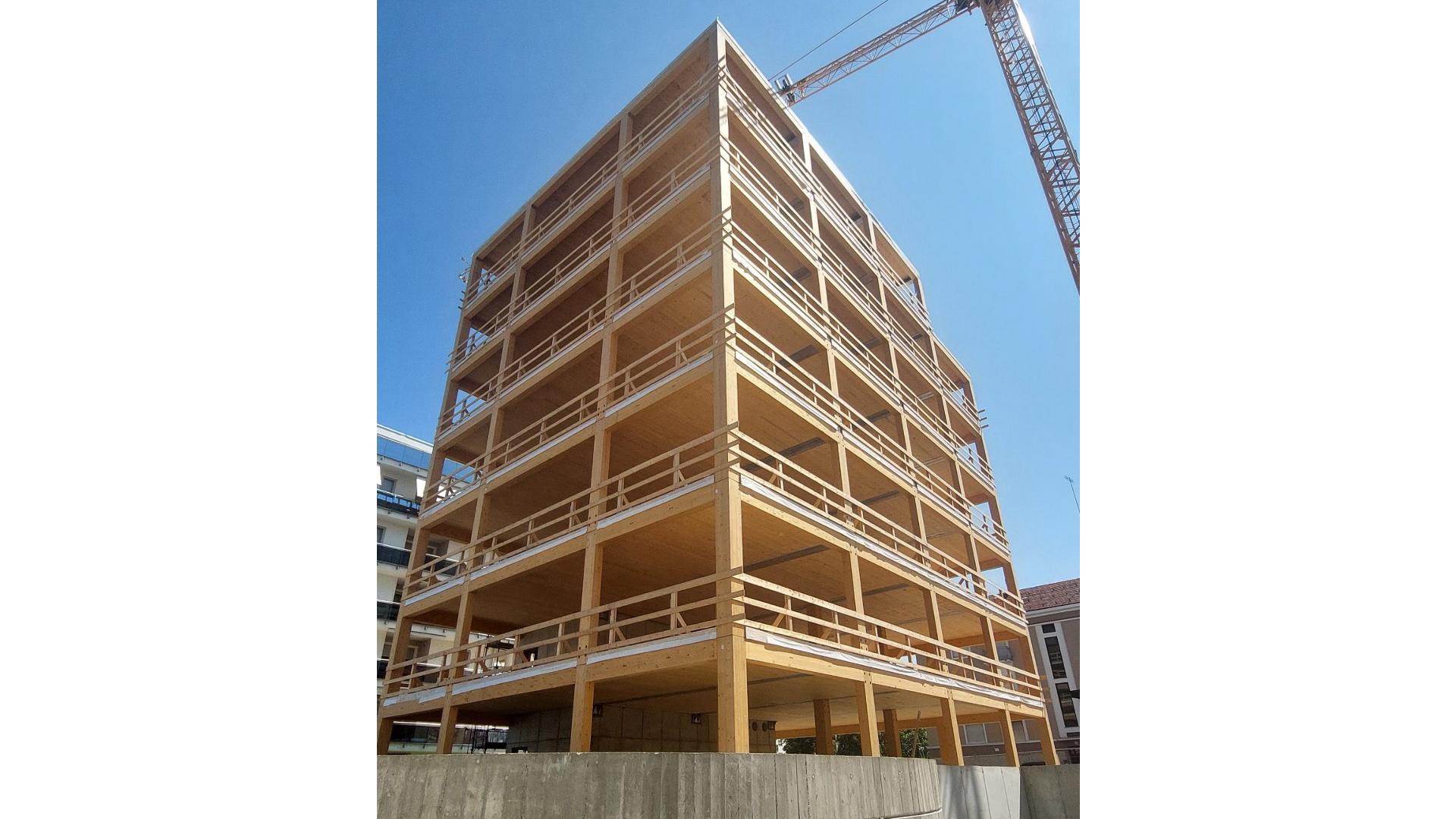 Timber construction site with temporary safety guardrails for prefabricated facade installation and off-site building retrofit