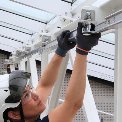 Interior view of a glazed building atrium with white steel roof trusses equipped with H-RAIL rope access system, installed by CGS Nordic for safe building maintenance.