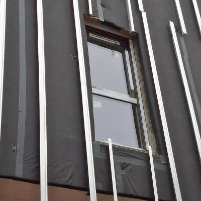 Ventilated façade under construction with breathable membrane and aluminum substructure for building envelope protection 