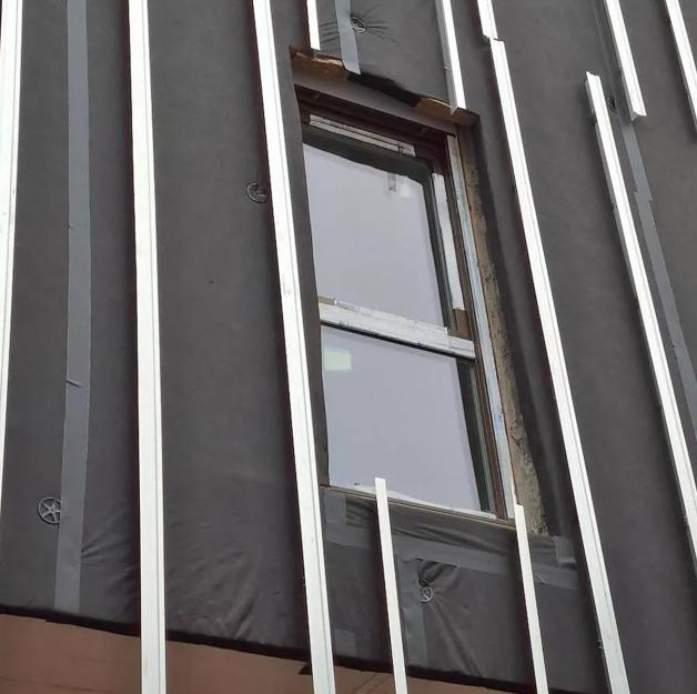 Ventilated façade under construction with breathable membrane and aluminum substructure for building envelope protection 