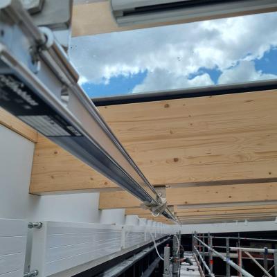  Rothoblaas H-RAIL horizontal lifeline system running along glulam timber beams of a large-span glazed timber roof during construction — Rebteknikeren ApS, Denmark.